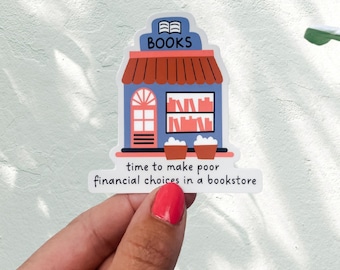 May include: A sticker featuring a cartoon bookstore with a red roof, blue walls, and the word "BOOKS" on top. The sticker includes the text "time to make poor financial choices in a bookstore."
