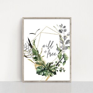 May include: A framed print featuring a gold geometric design and watercolour greenery. The text "wild & free" is written in black script.