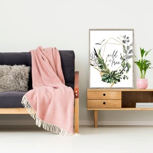May include: A framed print with a gold geometric design and watercolour greenery. The print features the text "wild + free" in black lettering.