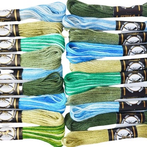 May include: A set of 20 embroidery floss spools in shades of blue, green, and beige. Each spool is labeled with "100% Egyptian Cotton" and "8 Metros".