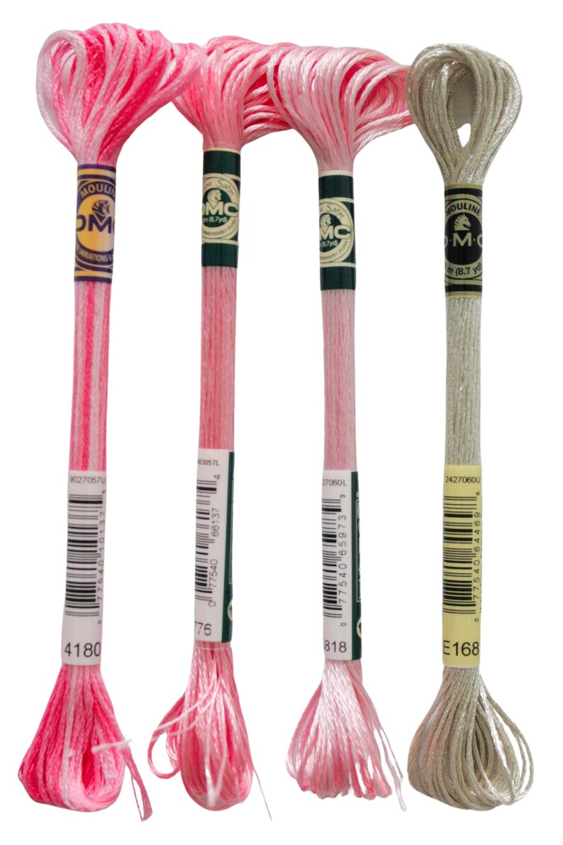 May include: Four spools of DMC embroidery floss. The spools are labeled with the DMC numbers 4180, 176, 818, and E168. The floss colors are pink, pink, pink, and light gray.