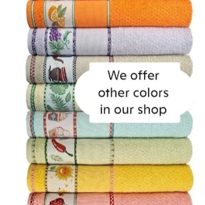 May include: A stack of colorful kitchen towels with fruit and vegetable designs. The towels are in shades of pink, orange, white, light blue, beige, green, yellow, and peach. The text "We offer other colors in our shop" is displayed.