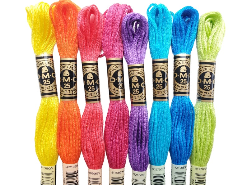 K&ouml;nnte beinhalten: Acht Spulen DMC Stickgarn in verschiedenen Farben, darunter Gelb, Orange, Rosa, Lila, Blau und Gr&uuml;n. Jede Spule ist mit dem Markennamen DMC und der Nummer gekennzeichnet.