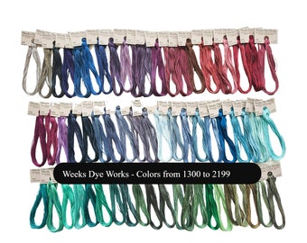 May include: A collection of Weeks Dye Works embroidery floss skeins arranged in rows, featuring a wide spectrum of colors including neutrals, purples, reds, blues, and greens. Each skein has a paper label with the text Weeks Dye Works.
