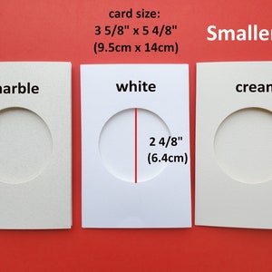 May include: Three cardstock cards with different colored backgrounds and a round hole cut out. The cards are labeled "marble", "white", and "cream". The card size is 3 5/8 inches by 5 4/8 inches (9.5 cm x 14 cm). The hole size is 2 4/8 inches (6.4 cm).