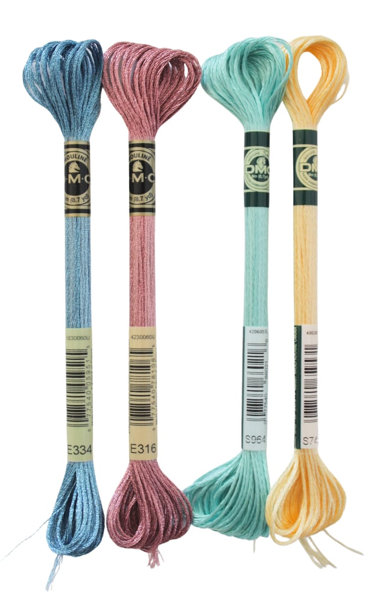 May include: Four skeins of DMC embroidery floss in pastel colors: light blue, dusty rose, seafoam green, and pale yellow. Each skein is labeled with a color code and brand information. The floss is tightly wound and ready for use.