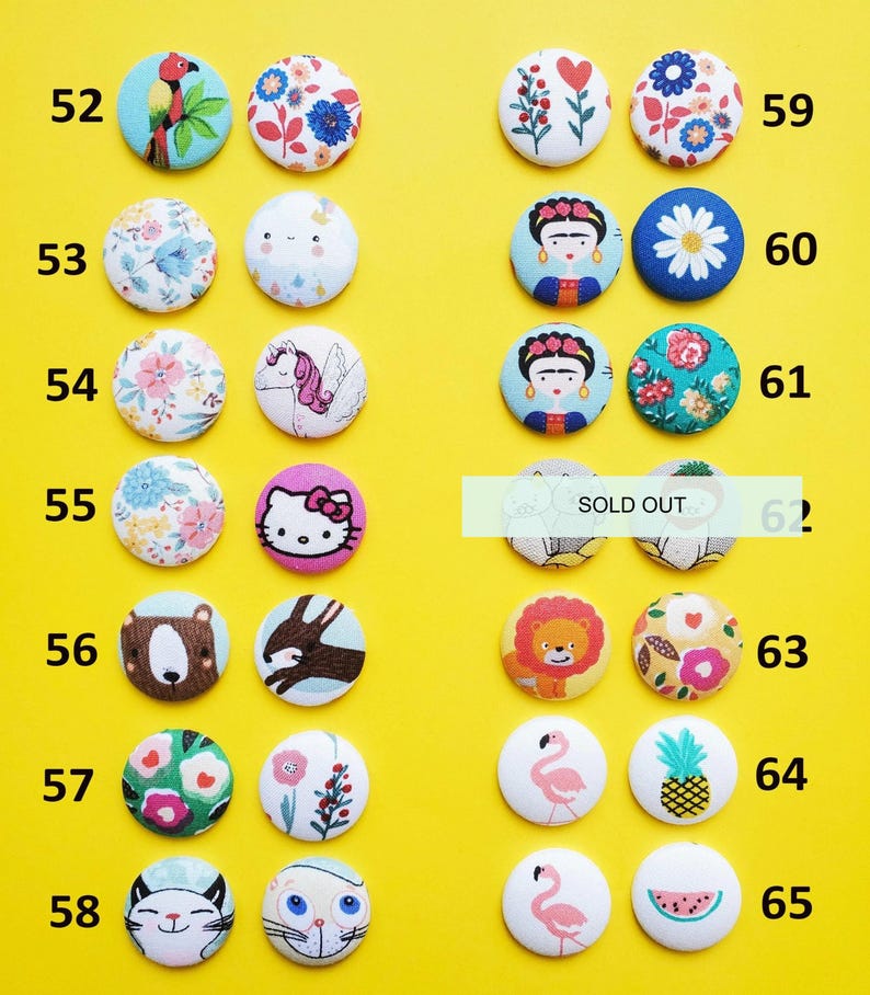 a collection of colorful buttons with various designs, including animals, flowers, and other decorative elements, arranged on a yellow background.