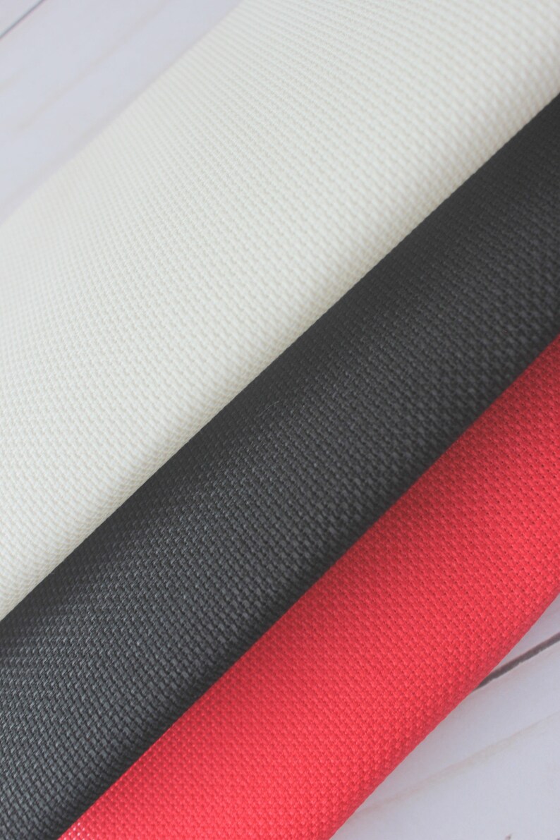 May include: Three fabric swatches in different colors: white, black, and red. The fabric has a textured weave.