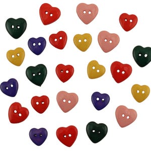 May include: A collection of heart-shaped buttons in various colors, including red, pink, yellow, green, and purple. Each button has two holes for sewing. The buttons are scattered against a white background.
