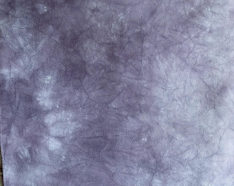 May include: Close-up of a piece of fabric with a mottled, tie-dye effect. The color is a muted purple with lighter, almost white, areas creating a textured appearance. The fabric has a woven texture, suitable for crafts.