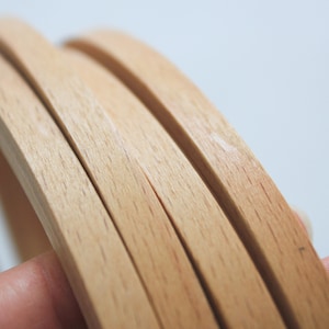 May include: Close-up of four wooden strips, stacked on top of each other, showing the grain of the wood.