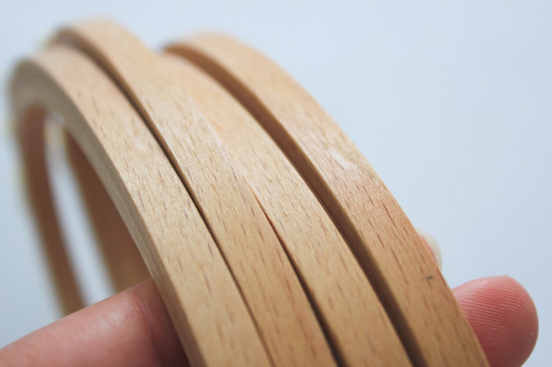 May include: Close-up of four wooden strips, stacked on top of each other, showing the grain of the wood.