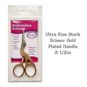 May include: Gold-plated embroidery scissors with a stork design. The scissors are 3 1/2 inches long and have precision pointed blades. The packaging says "Ultra Fine Stork Scissor Gold Plated Handle 3 1/2in".