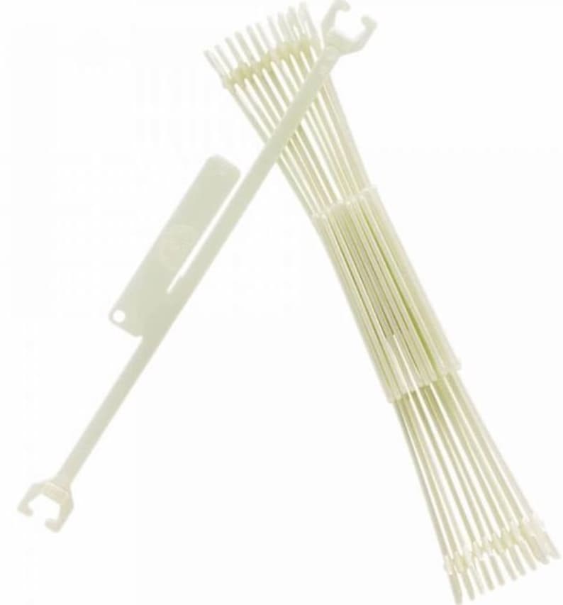 Op de afbeelding: Een set witte plastic breinaalden met een haak aan het ene uiteinde. De naalden zijn gebundeld en hebben een wit plastic gereedschap met een haak aan het ene uiteinde.