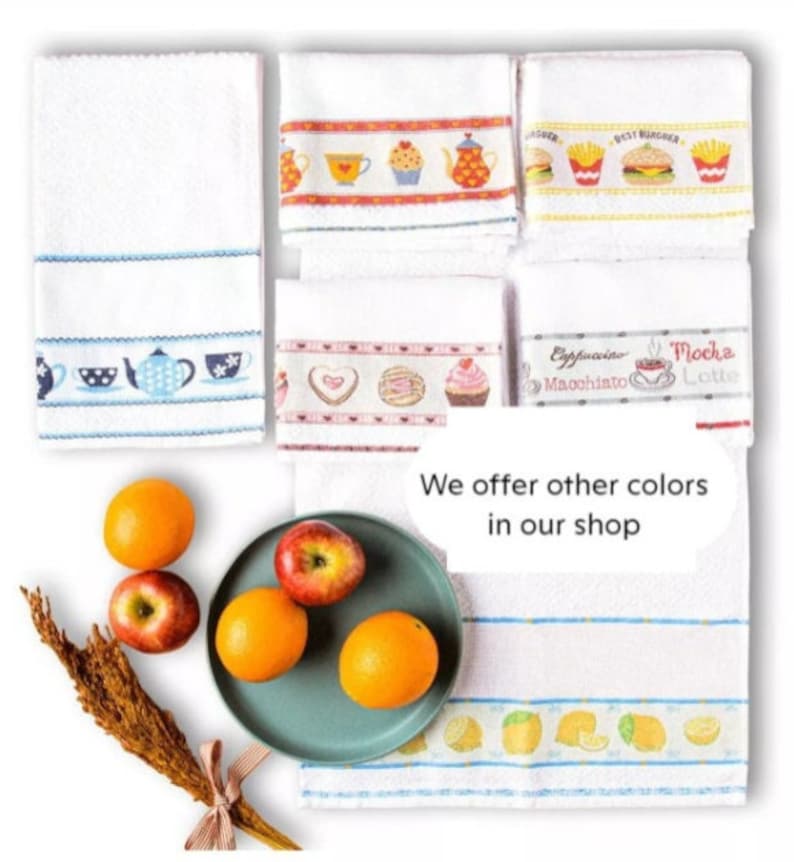 May include: White kitchen towels with embroidered designs. Some towels feature teacups, teapots, and desserts. Others have images of burgers and fries. The image also includes oranges, apples, and a sprig of wheat.