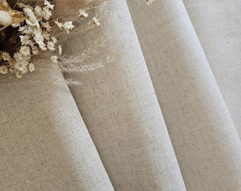 May include: Close-up of beige linen fabric with a subtle woven texture, draped in soft folds. A bouquet of dried flowers, including white daisies and fluffy beige grasses, rests on the fabric, adding a touch of natural elegance. The neutral tones create a calming aesthetic.