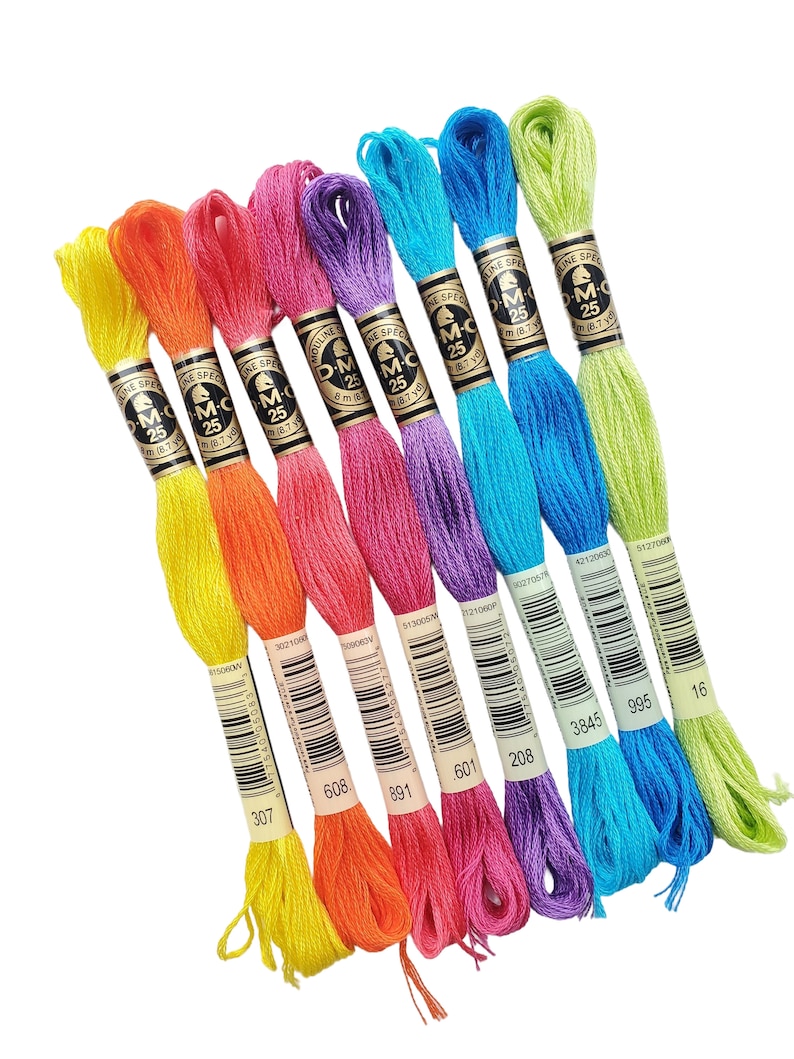 K&ouml;nnte beinhalten: Ein Set mit zehn DMC Stickgarn-Spulen in verschiedenen Farben, darunter Gelb, Orange, Rosa, Lila, Blau und Gr&uuml;n. Jede Spule hat ein wei&szlig;es Etikett mit dem DMC-Logo und der Nummer der Garnfarbe.