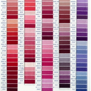 May include: A color chart from DMC featuring a wide range of embroidery floss shades. The chart displays numbered color swatches in various hues of pink, red, purple, and blue, ideal for cross-stitch and needlepoint projects.