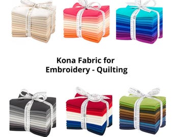 Könnte beinhalten: Sechs Stapel gefalteter Kona-Stoffe, zusammengebunden mit weißen Maßband-Schleifen. Die Stapel zeigen verschiedene Farbpaletten, darunter Neutraltöne, Rosa, Blau, Grau, Primärfarben und Grün. Der Text lautet: Kona Fabric for Embroidery - Quilting.