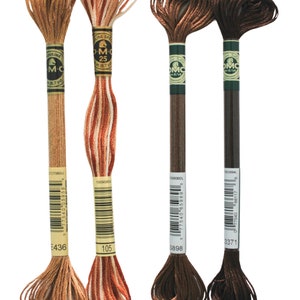 May include: Four spools of DMC embroidery floss in shades of brown, orange, and white. The spools are labeled with the DMC numbers 3371, 5898, 105, and 436.