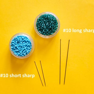 May include: Two clear jars filled with turquoise and teal beads, alongside three needles. The text "#10 long sharp" and "#10 short sharp" are visible. The items are arranged on a bright yellow surface.