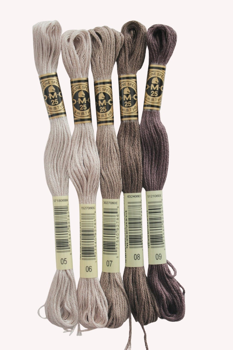 Peut inclure: Cinq bobines de fil &agrave; broder DMC dans des tons beige, brun et violet. Les bobines sont &eacute;tiquet&eacute;es avec les num&eacute;ros de couleur DMC 05, 06, 07, 08 et 09.