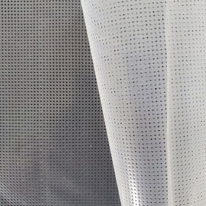 May include: A white, translucent mesh fabric with a grid pattern of small, evenly spaced holes. The fabric is folded in half, revealing the underside.