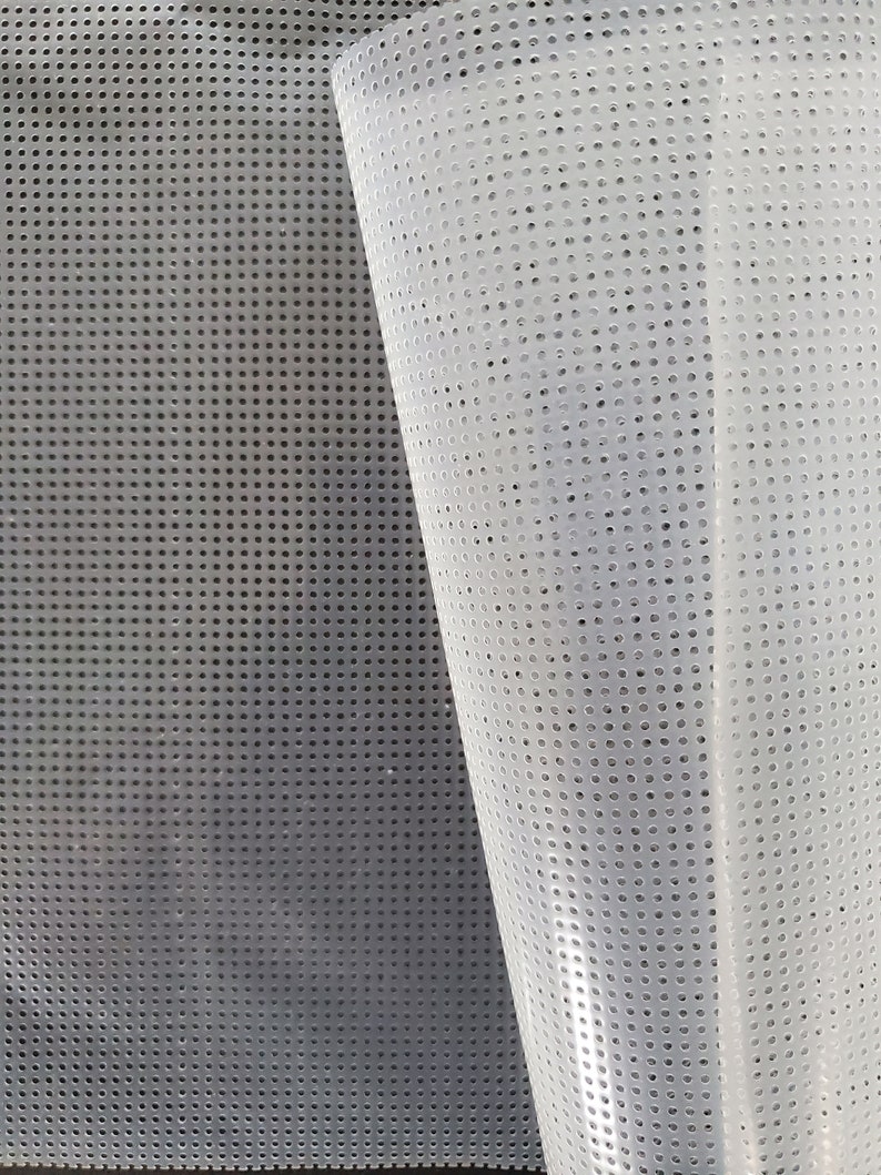 May include: A white, translucent mesh fabric with a grid pattern of small, evenly spaced holes. The fabric is folded in half, revealing the underside.