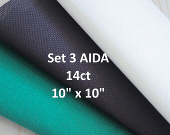 Op de afbeelding: Set van drie 25,4 cm bij 25,4 cm Aida-stof vierkanten in zwart, wit en groen. De stof is 14-counts.