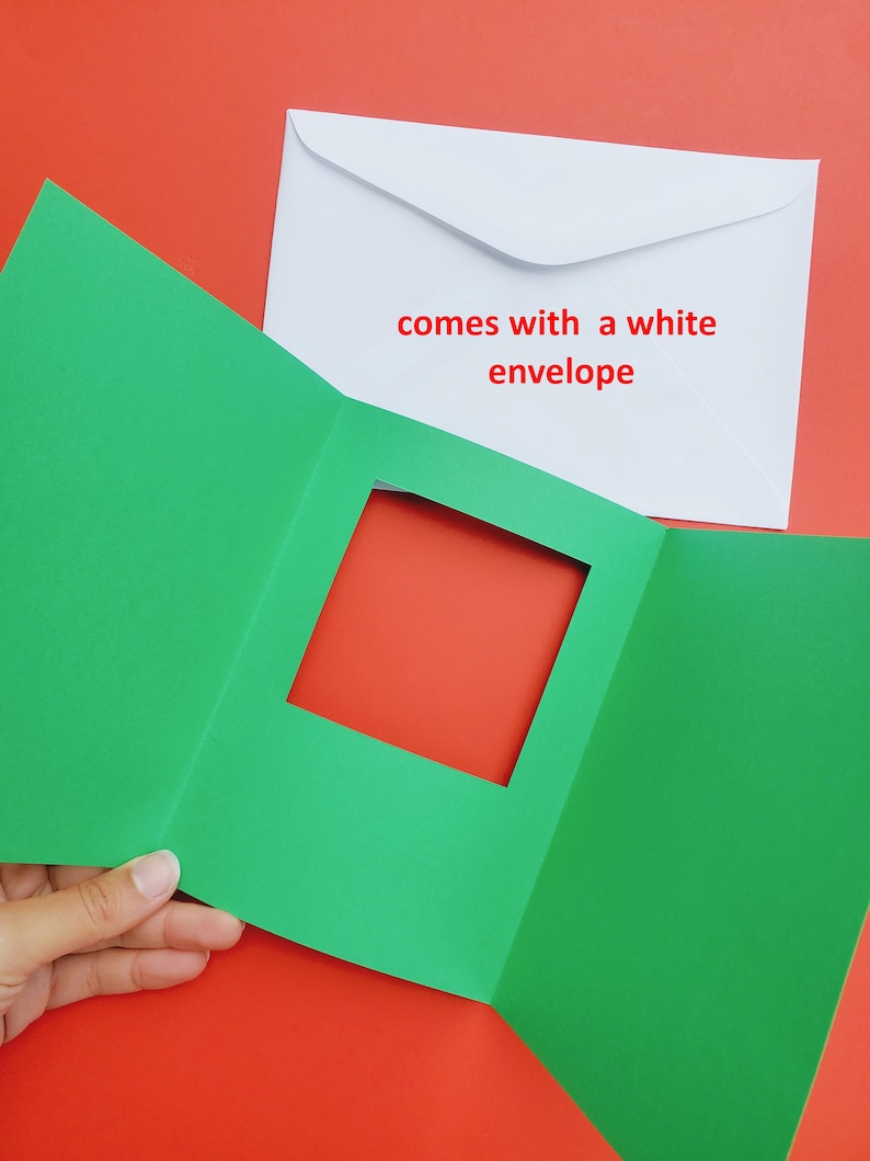 May include: A green card with a square window cut out. The card is folded in thirds. The card comes with a white envelope. The text on the envelope reads "comes with a white envelope".