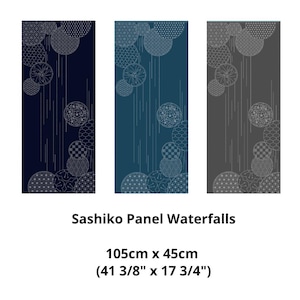 May include: Three rectangular panels with a Japanese sashiko design. Each panel is a different colour: navy blue, teal, and grey. The design includes white circles with various patterns and vertical lines. The text "Sashiko Panel Waterfalls" is below. The panels are 105cm x 45cm.