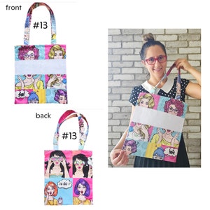 May include: A pink and blue tote bag with a pop art design featuring women with sunglasses and speech bubbles. The bag has a white panel for personalization. The bag is shown from the front and back.