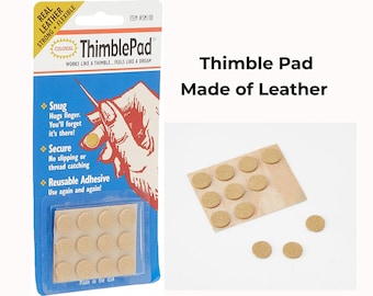 以下が含まれることがあります： 裁縫用のColonial ThimblePad粘着レザーサークル。青と白のパッケージには「Real Leather」、「Snug」、「Secure」、「Reusable Adhesive」などの文字が記載されています。ベージュの円形パッドのシートが含まれています。