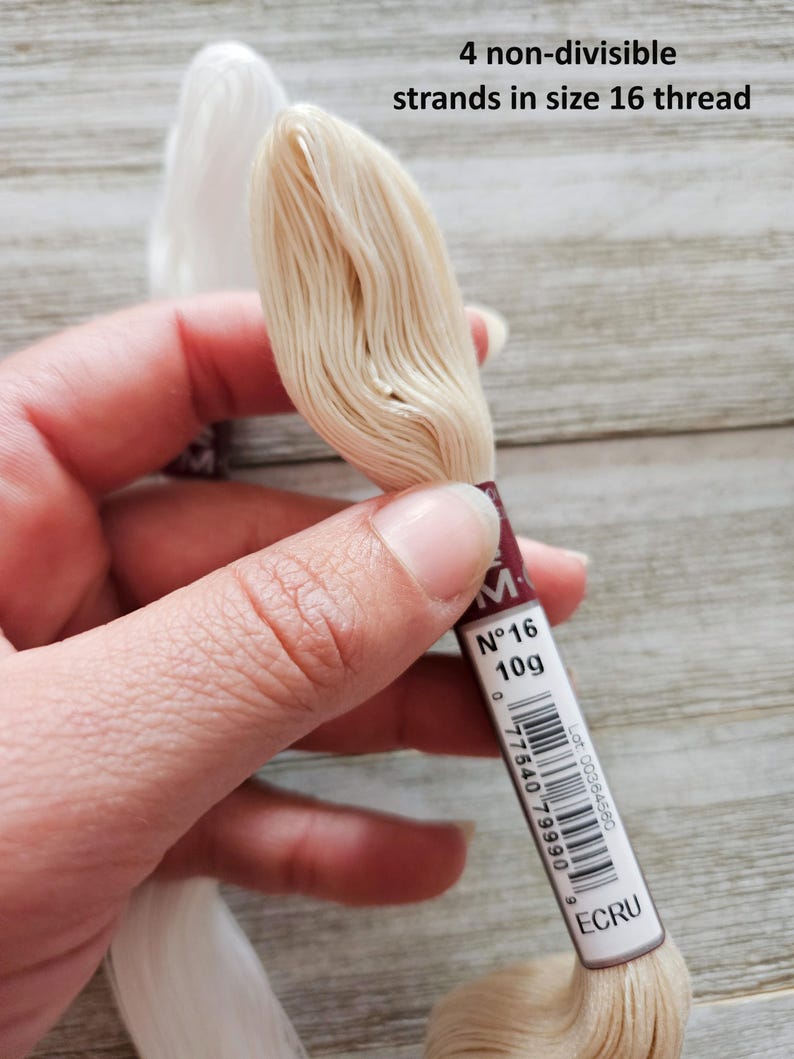 May include: Close-up of two spools of embroidery thread. One spool is white, and the other is ecru. The ecru spool is labeled "N&deg;16 10g" and "ECRU". The text "4 non-divisible strands in size 16 thread" is also visible.