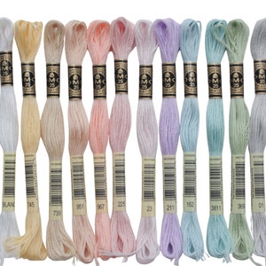 May include: A collection of 12 DMC embroidery floss spools in various pastel shades, including white, yellow, pink, lavender, and green. Each spool is labeled with the DMC color number and the brand name.