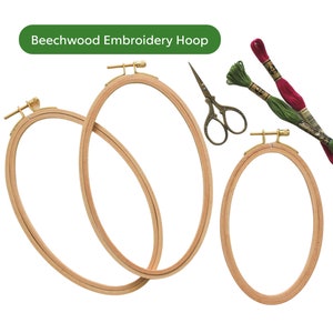 May include: Three wooden embroidery hoops of different sizes, with a pair of small scissors and two spools of embroidery floss in red and green.