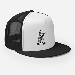 May include: A black and white illustration of a German Shepherd dog peeking out from behind a white and black trucker hat. The hat has a black mesh back and a white front.