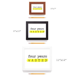 May include: Three framed prints with the text "four years wasted" in black text on a white background. The text is highlighted with a yellow stripe. The frames are brown wood, black, and white. The prints are 5 inches by 7 inches, 8 inches by 10 inches, and 11 inches by 14 inches.