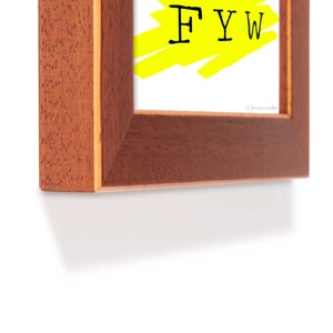 May include: A wooden picture frame with a yellow background and the text "FYI" in black.