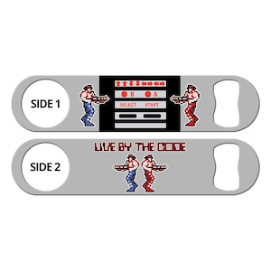 May include: A silver bottle opener with a black and white video game design on one side and the text "LIVE BY THE CODE" on the other side. The video game design features two pixelated characters holding guns and a control panel with buttons labeled "A", "B", "SELECT", and "START".