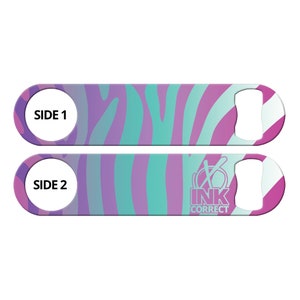 May include: A pink and blue zebra patterned bottle opener with the text "SIDE 1" on one side and "SIDE 2" and "INK CORRECT" on the other side.