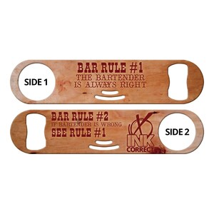 May include: Wooden bottle opener with a brown wood finish. The front side has the text "BAR RULE #1 THE BARTENDER IS ALWAYS RIGHT". The back side has the text "BAR RULE #2 IF BARTENDER IS WRONG SEE RULE #1" and a logo that says "INK CORRECT".