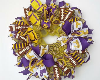 May include: A circular wreath with yellow and purple ribbons, football-shaped decorations, and tiger motifs. The wreath is designed for home decoration, with a diameter of approximately 30 cm.