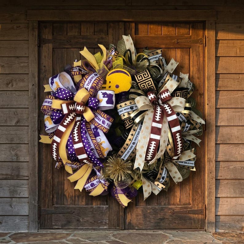 May include: A decorative wreath featuring football and team-themed ribbons in purple, gold, and white. The wreath includes a miniature yellow football helmet and accents with football laces. The wreath is displayed on a wooden door.