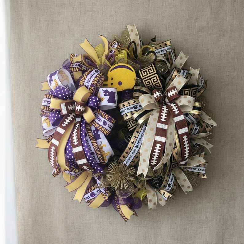 May include: A decorative wreath featuring football-themed ribbons in purple, gold, and brown. The wreath includes a small yellow football helmet and ribbons with the text "Tigers" and "New Orleans".