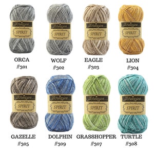 May include: Eight skeins of Scheepjes Spirit yarn in various color combinations. The yarn is a variegated blend of colors, including gray, brown, blue, green, and yellow. Each skein is labeled with the brand name, yarn name, and a color number.