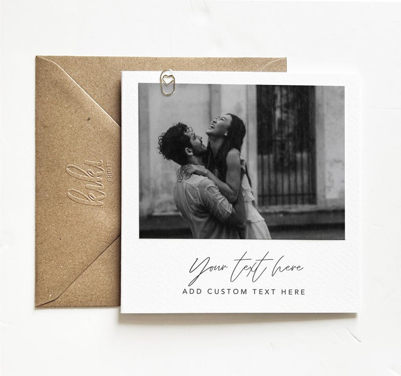 Puede incluir: Impresi&oacute;n estilo polaroid en blanco y negro con una pareja riendo y abraz&aacute;ndose. La impresi&oacute;n incluye el texto "Your text here" y "Add custom text here". Tambi&eacute;n se ve un sobre marr&oacute;n y un clip en forma de coraz&oacute;n.