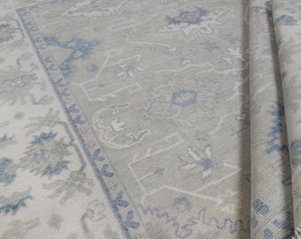 May include: A light gray rug with a blue and white patterned design. The rug has a traditional Persian style.