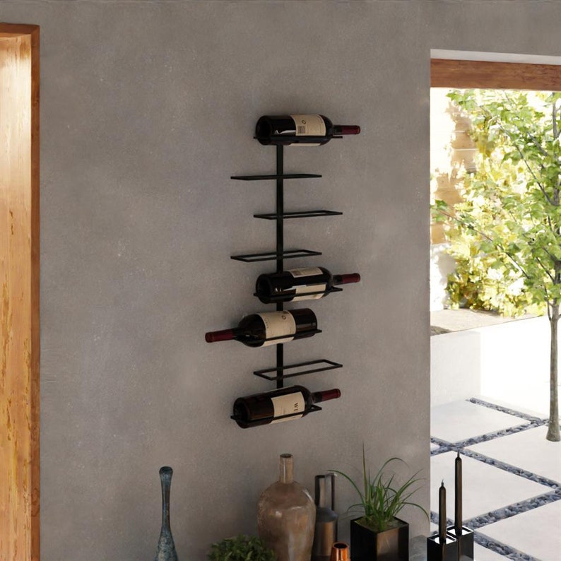 May include: A black metal wall-mounted wine rack holding four bottles of wine. The rack has a minimalist design with horizontal bars to support the bottles. The wine bottles are dark with red labels.