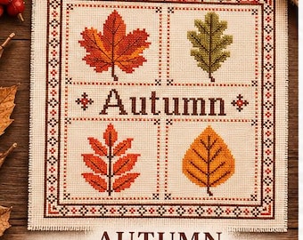 May include: A square cross stitch sampler on cream fabric featuring a decorative border and four quadrants, each displaying a different autumn leaf in red, green, orange, and yellow. The word Autumn is stitched in brown in the center.